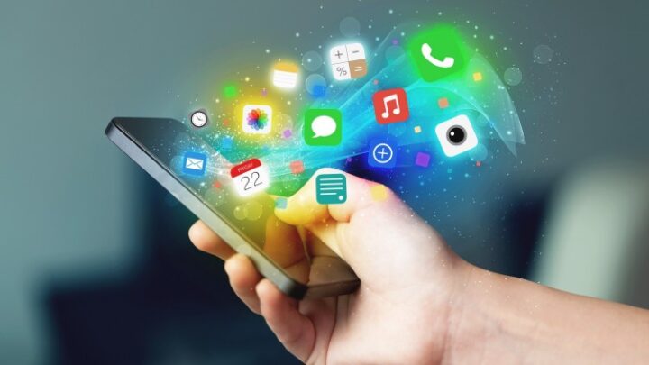 A hand with a cell phone and a cloud of app icons